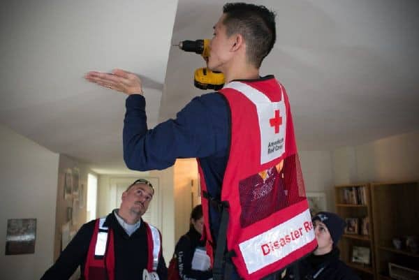 A man installing smoke detectors